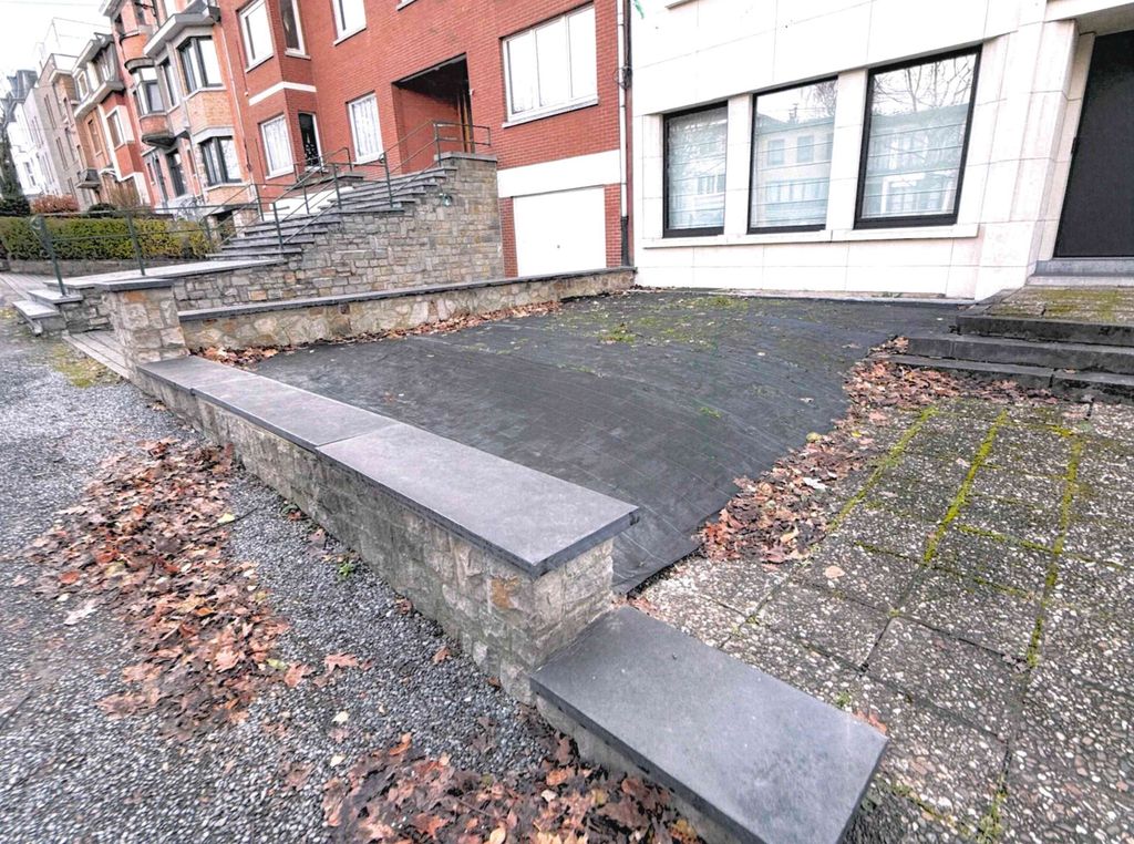 Avant travaux : allée en pente aux dalles disjointes entre deux murets de pierre, à Verviers