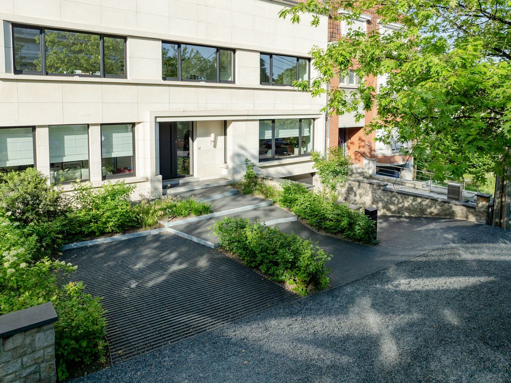 Vue aérienne de l'allée d'accès en pavés drainants et des parterres plantés devant une maison moderne à Verviers